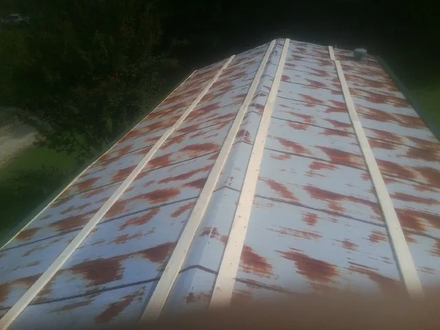 Rusted metal roof panels with new wood purlins before replacement — Storm Damage Roof Repair in Belfield by Roofing Brothers