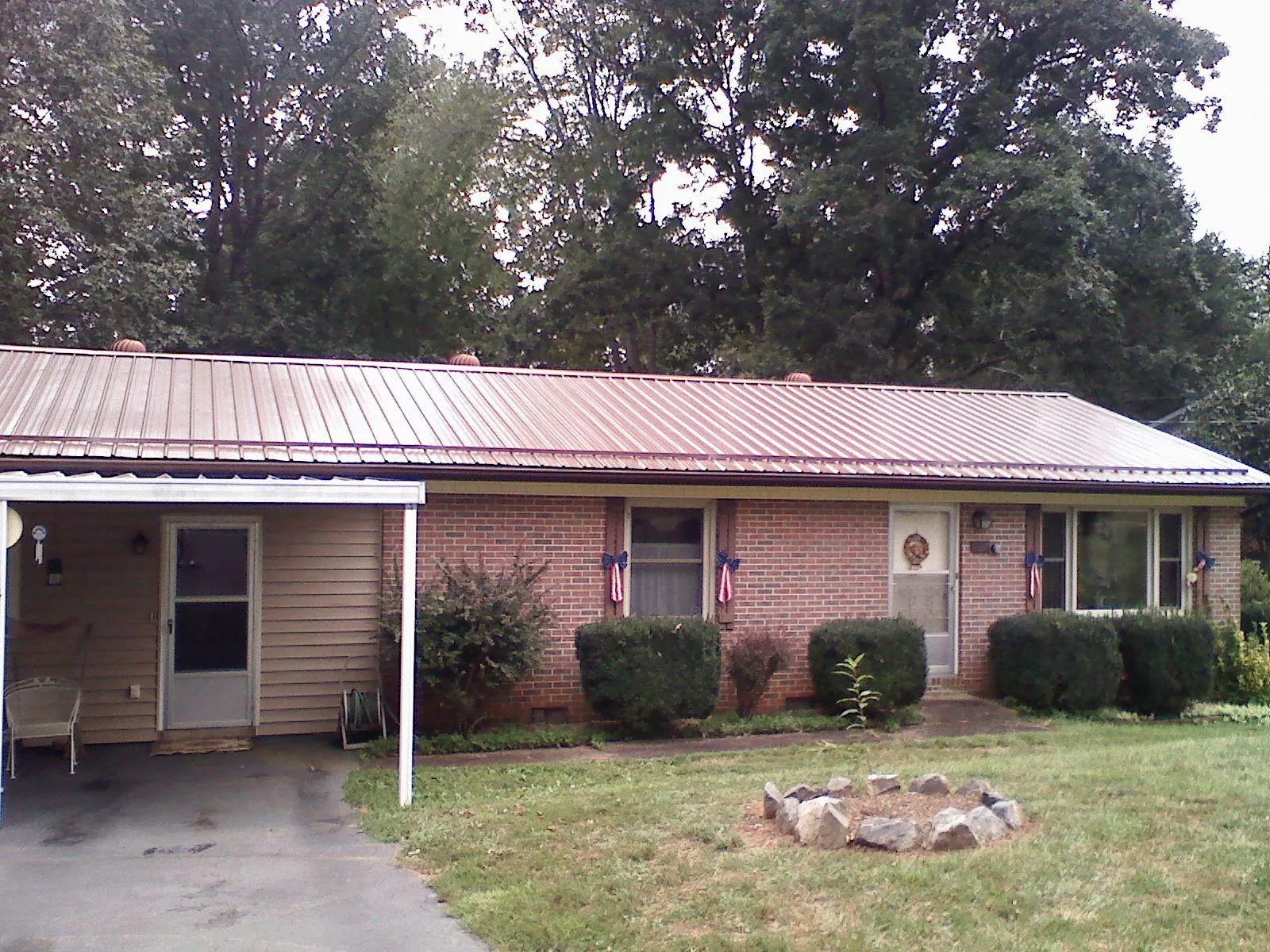 Bronze metal roof and carport on a brick ranch home — Roof Repair work by our crew in Belfield